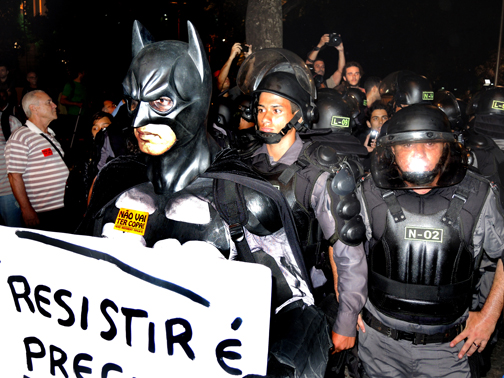 Batman stands his ground calling for resistance in front of a pack of Policia Militar